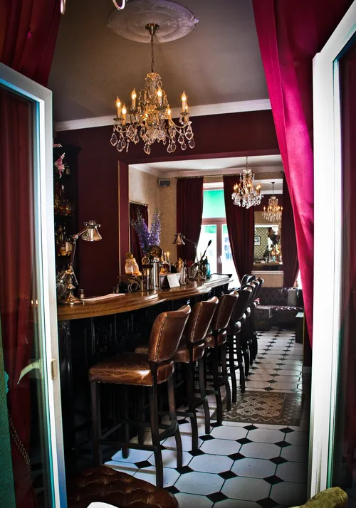 Narrow bar room with red curtains and a chandelier at Seiberts