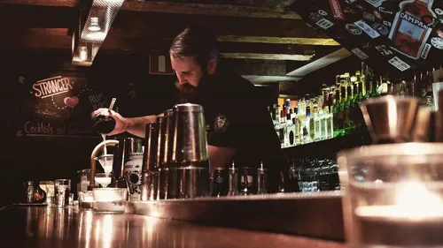 Bartender mixing drinks behind the bar in Gothenburg