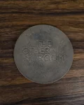 Engraved coin on a wooden bar top at The Other Room