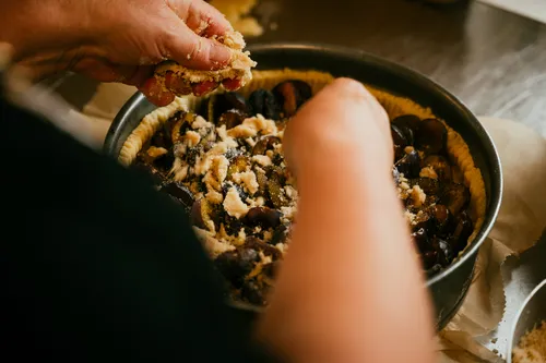 Sprinkling crumble over the plum cake
