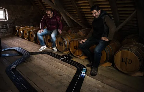 Two men sitting beside oak barrels in the granary attic
