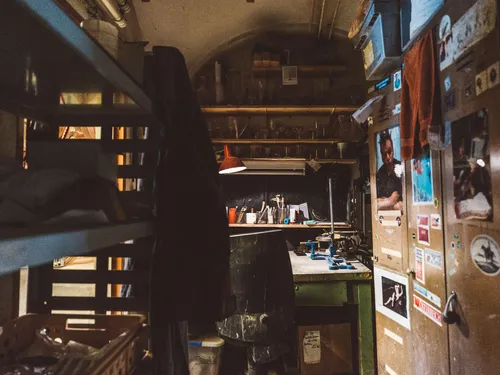 Cluttered glass workshop with tools and shelves