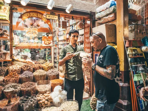 Two men talking at a spice shop in the souk