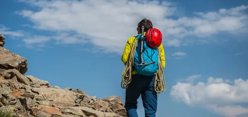 Climber with helmet standing on a mountain ridge