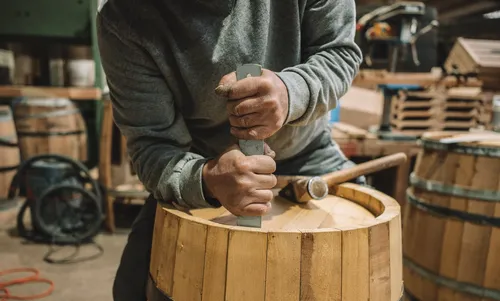 Cooper working on the rim of an oak barrel
