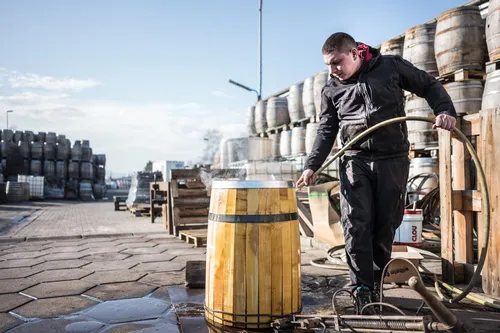 Cooper rolling a barrel in the cooperage yard