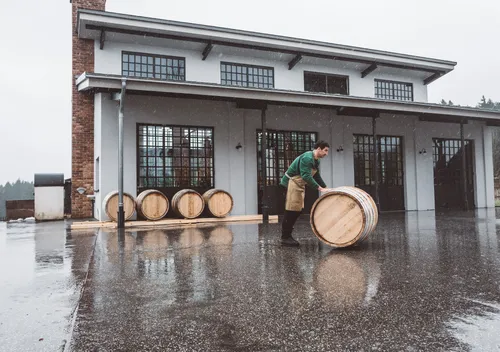 Distiller rolling barrels in front of the Monkey 47 distillery