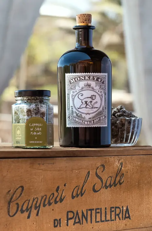 Monkey 47 Distiller's Cut 2024 bottle with glass on a Pantelleria caper crate