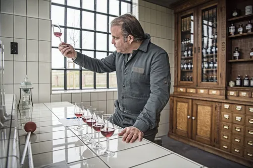 Monkey 47 distiller nosing a glass of Schwarzwald Sloe Gin at a tasting counter