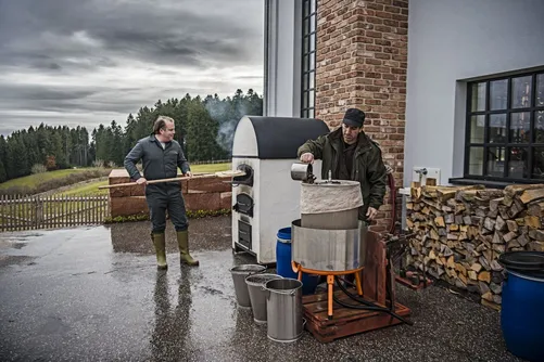 Men working at a still outside a Black Forest farmhouse