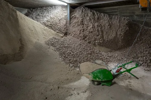 Heap of clay granulate with a green wheelbarrow