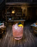 Bramble cocktail with blackberry and lemon over crushed ice
