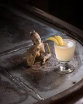 Corpse Reviver #2 with a lemon twist next to a figurine