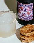 From Rags to Riches drink on ice with a Monkey 47 Sloe Gin bottle and biscuits