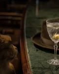 Martini with an olive beside a hat and a monkey figure