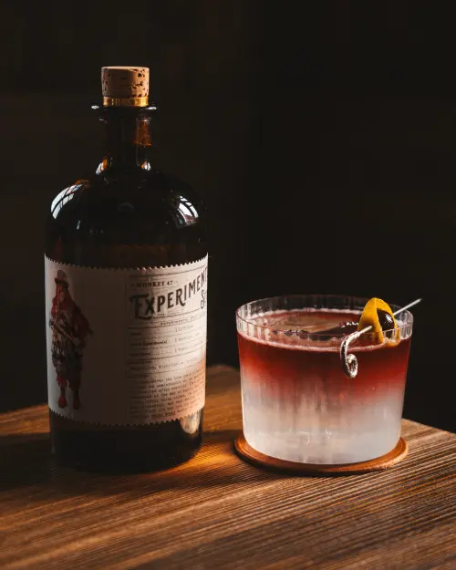 Perugia Sour next to a gin bottle