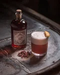 Sloe Gin Fizz next to a Monkey 47 Sloe Gin bottle