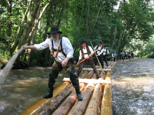 Rafters on a log raft floating down a Black Forest river