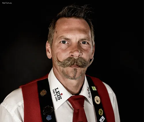 Man with a curled moustache in traditional costume with red braces