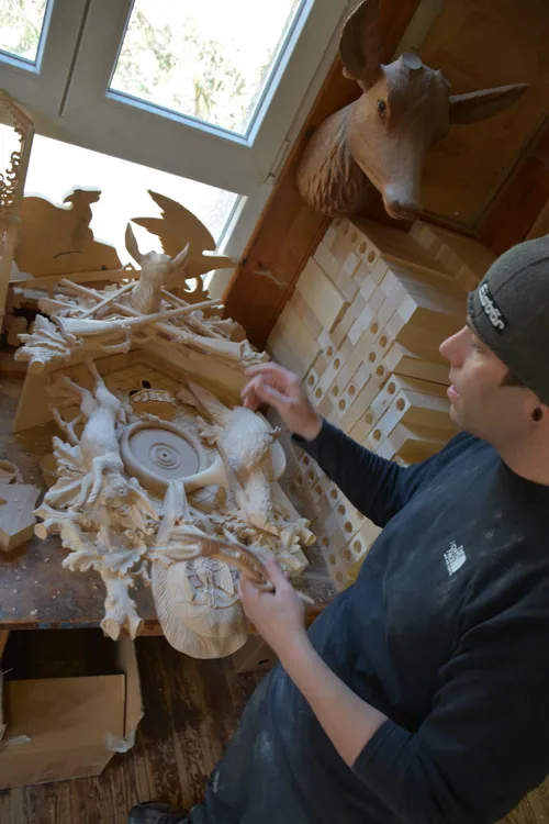 Woodcarver working on an ornate cuckoo clock