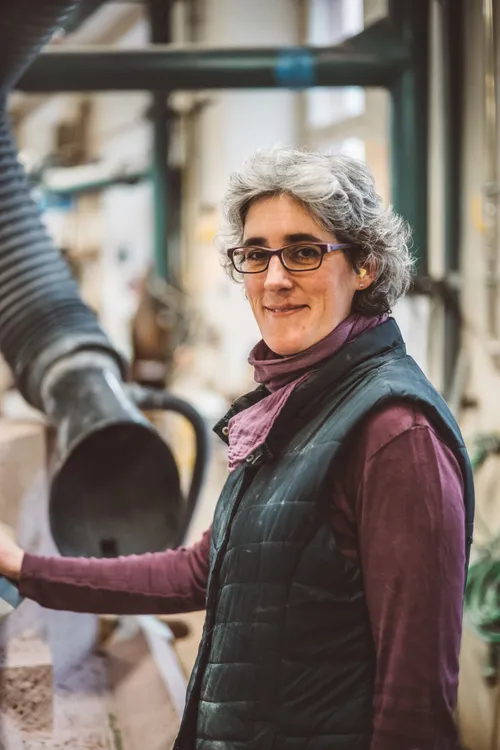 Smiling stonemason in her workshop