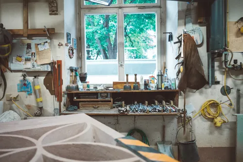 Stonemason's workshop with tools and a stone tracery piece
