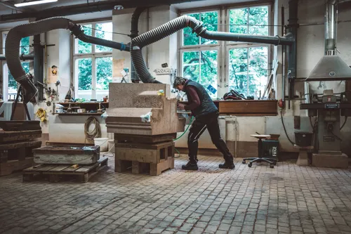 Workshop hall with a stonemason working at a bench