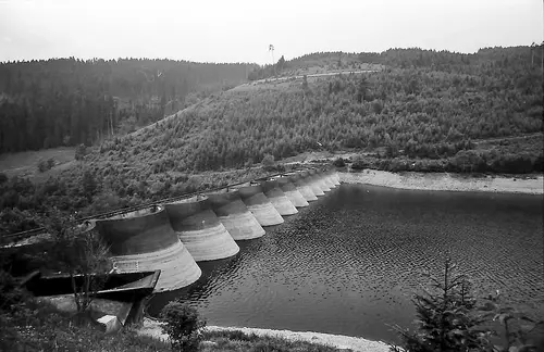 Black-and-white photo of the Linach dam in a wooded valley