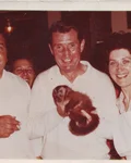 Old photo of people at the Affenbar holding a small monkey