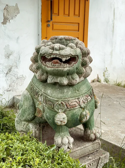 Stone lion guardian statue in front of a temple door