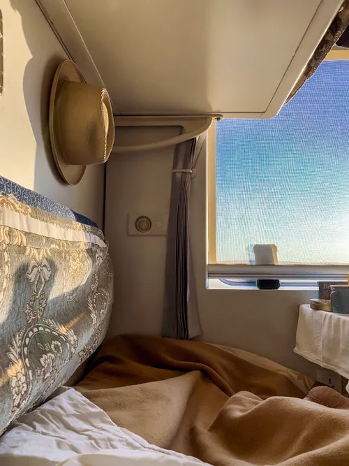 Bunk with pillows by the compartment window