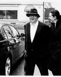 Black-and-white photo of Thomas Grässlin beside a car