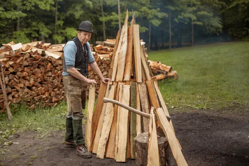 Charcoal burner building the wood pile for a charcoal kiln