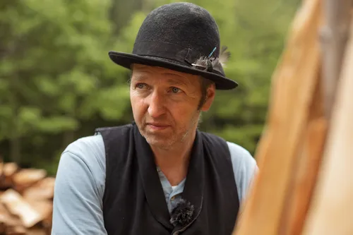 Charcoal burner in a black hat and waistcoat