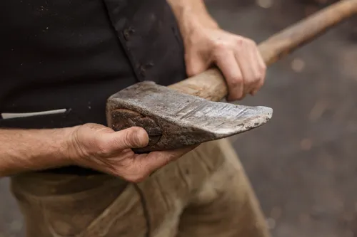 Hands holding a large wooden mallet