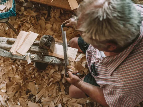 Shingle maker shaping wood on a shaving horse
