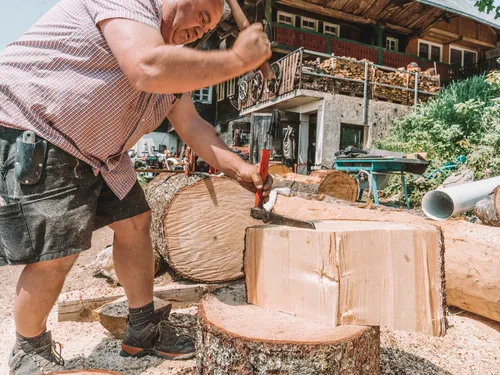 Man splitting a block of wood with a mallet