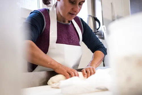 Cheesemaker shaping curd by hand