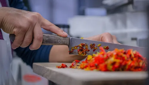 Knife chopping edible flowers on a cutting board